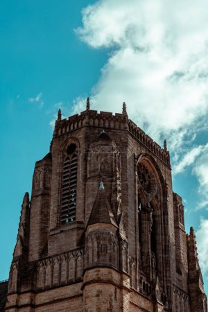 Téléchargez les photos : Un plan en angle bas de l'église du Saint-Nom de Jésus sur Oxford Road, Manchester, avec un ciel nuageux en arrière-plan - en image libre de droit