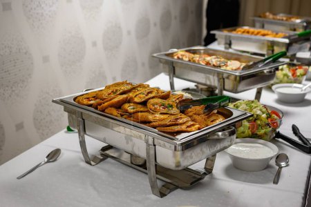 Photo for A buffet full of different dishes such as salads and cutlets on metal plates - Royalty Free Image