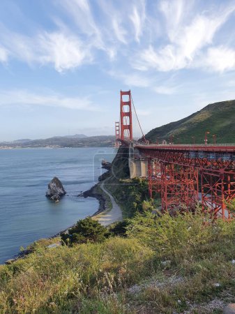 Téléchargez les photos : Un plan vertical du Golden Gate Bridge sur les eaux avec les collines et le ciel bleu en arrière-plan - en image libre de droit