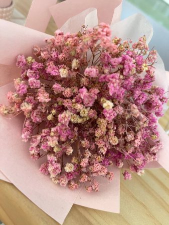 Foto de Una vista superior del ramo de flores de aliento de bebé en una mesa de madera - Imagen libre de derechos