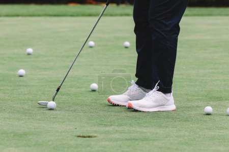 Téléchargez les photos : Pieds de golfeur jouant au golf sur le terrain par une journée ensoleillée - en image libre de droit