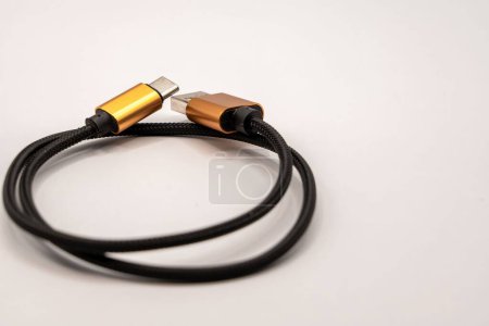 Foto de Cierre detallado de un cable USB trenzado negro con conectores de color dorado - Imagen libre de derechos