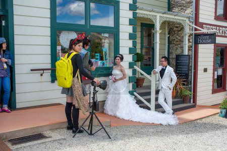 Photo for The photographer taking pictures of newlyweds by the cute buildings in Cromwell, Otago, New Zealand - Royalty Free Image