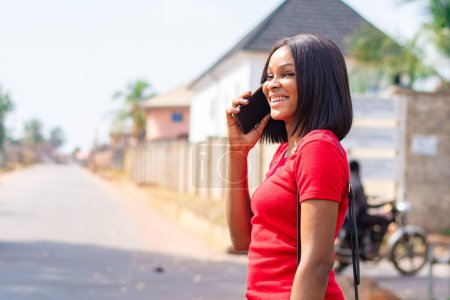 Photo for Pretty african lady making a phone call smiling - Royalty Free Image