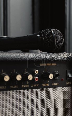 Téléchargez les photos : Gros plan vertical d'un microphone sur un amplificateur de guitare rétro dans un studio - en image libre de droit