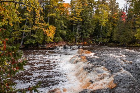 Téléchargez les photos : Les chutes inférieures pittoresques du parc d'État de Tahquamenon Falls dans le Michigan entouré de feuillage d'automne - en image libre de droit