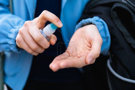 Eine Nahaufnahme der Hände einer Frau mit einem Händedesinfektionsmittel - das Konzept einer Pandemie