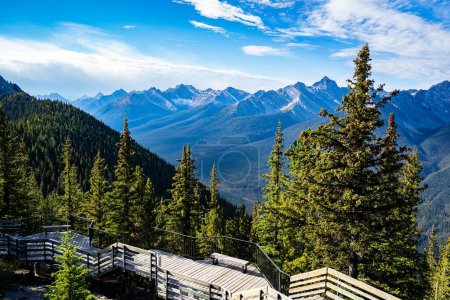 Téléchargez les photos : Une vue fascinante sur Sulphur Mountain, Canada depuis le sommet de la montagne, par une journée ensoleillée, avec des pentes verdoyantes en arrière-plan - en image libre de droit