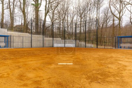 Photo for View of typical nondescript high school softball clay infield looking from pitching rubber toward home plate. No people visible. Not a ticketed event. - Royalty Free Image