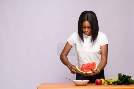 Foto de Hermosa dama negra cortando algunas frutas - Imagen libre de derechos