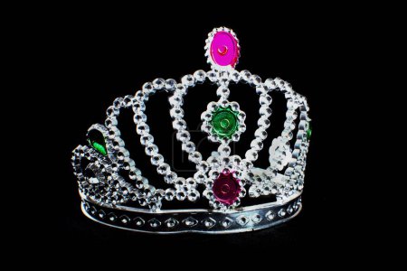 Téléchargez les photos : Une princesse tiare en argent avec des pierres colorées isolées sur un fond noir - en image libre de droit