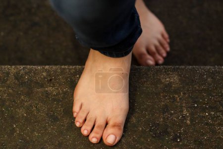 Téléchargez les photos : Les pieds nus monter les escaliers - en image libre de droit
