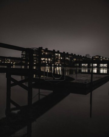 Téléchargez les photos : Le pont sur l'eau avec des bâtiments en arrière-plan la nuit - en image libre de droit
