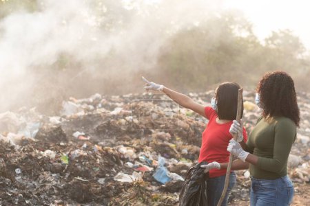 Téléchargez les photos : Femmes africaines nettoyage d'un site de déchets - en image libre de droit