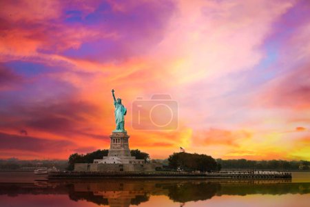 Foto de La estatua de la libertad en Nueva York con gran puesta de sol - Imagen libre de derechos