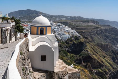 Foto de La pintoresca iglesia con el pueblo de Fira en el fondo, Santorini, Grecia - Imagen libre de derechos