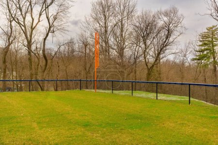 Photo for View of typical nondescript high school softball left outfield orange foul pole. No people visible. Not a ticketed event. - Royalty Free Image