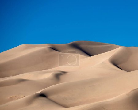 Foto de Una hermosa vista de grandes dunas bajo el cielo despejado durante el amanecer - Imagen libre de derechos