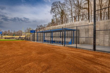 Photo for View of typical nondescript high school softball clay infield from infield near home plate looking toward the first base dugout. No people visible. - Royalty Free Image