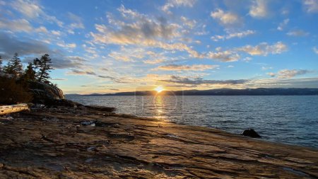 Téléchargez les photos : Une belle vue sur la scène du lever du soleil sur le lac et les montagnes à l'horizon - en image libre de droit