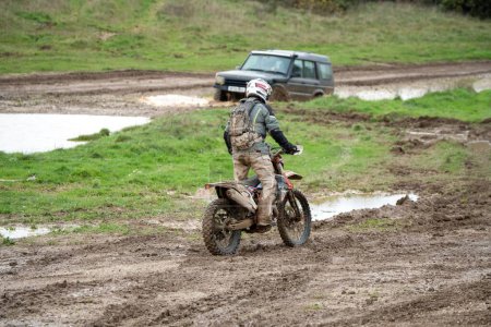 Téléchargez les photos : Une moto hors route parcourue sur un terrain boueux pendant la journée - en image libre de droit