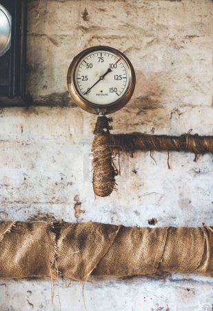 Photo for A vertical view of the vintage team engine pressure gauge and lagged pipes - Royalty Free Image