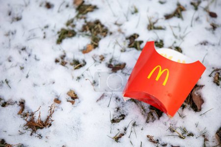 Téléchargez les photos : Un gros plan d'un conteneur de frites McDonalds sur un sol enneigé - en image libre de droit