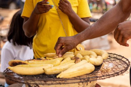 Téléchargez les photos : Afrique personnes achetant plantain rôti - en image libre de droit