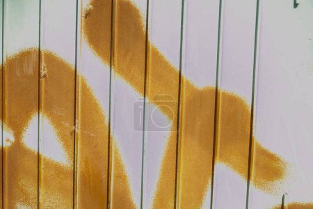 Foto de Un primer plano de una cerca blanca con pintura en aerosol amarillo - Imagen libre de derechos