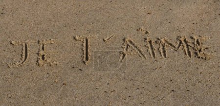 Foto de Un plano panorámico de un texto "I love you" en francés escrito en una arena de playa - Imagen libre de derechos