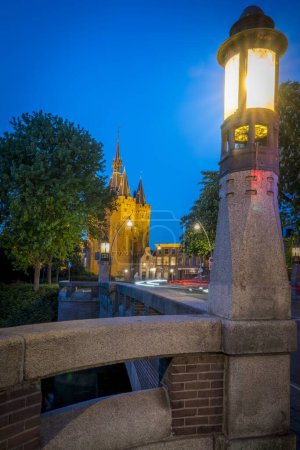 Photo for A vertical closeup shot of a lamppost on a bridge with the Sassenpoort building in Zwolle, Netherlands - Royalty Free Image