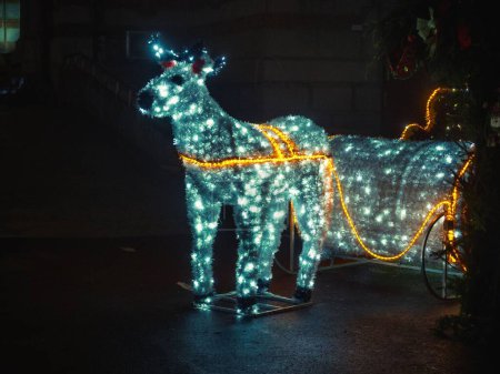 Photo for A beautiful shot of a reindeer statue lighten up for Christmas - Royalty Free Image