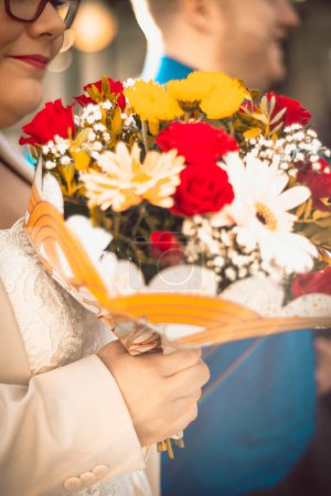 Photo for A wedding guest holding  a beautiful bouquet of flowers - Royalty Free Image