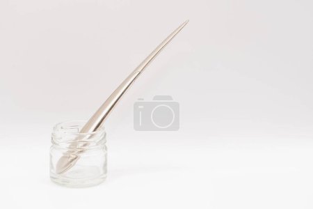 Foto de Un brillante cromado cuchillo de acero abrecartas de pie en un frasco de vidrio transparente - Imagen libre de derechos