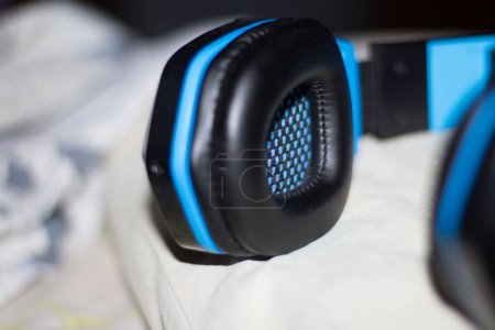 Photo for A closeup shot of a blue and black headset placed on a white cloth - Royalty Free Image