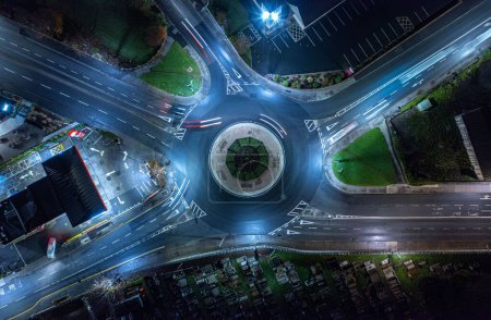 Téléchargez les photos : Un long plan d'exposition de la circulation sur le cercle de la circulation avec des lanternes de rue éclairées dans la nuit - en image libre de droit