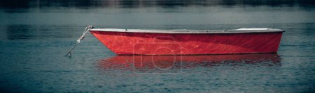 Foto de Un plano panorámico de una lancha roja en el lago en primer plano - Imagen libre de derechos