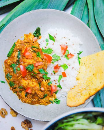 Téléchargez les photos : Une vue verticale d'un repas au curry indien servi avec du riz sur une assiette en verre - en image libre de droit