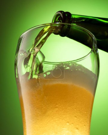 Foto de Un disparo vertical de una cerveza en un vaso del grifo - Imagen libre de derechos