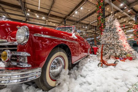 Foto de Un coche rojo clásico con nieve falsa y decoraciones navideñas en un museo - Imagen libre de derechos