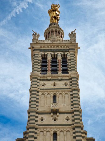 Photo for The low-angle view of Basilique Notre-Dame de la Garde tower against the cloudy blue sky - Royalty Free Image