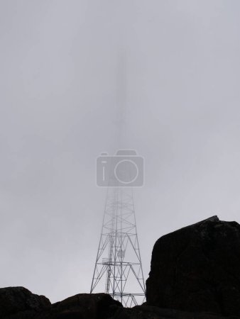 Foto de Un disparo vertical de una línea eléctrica metálica en la niebla en Tasmania, Australia - Imagen libre de derechos