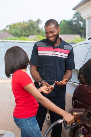 african petrol station attendant selling fuel to a customer