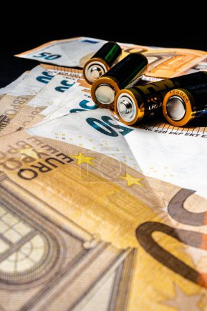 Téléchargez les photos : Gros plan, 4 piles AA posées sur une pile de billets de 50 euros, représentant argent vs énergie - en image libre de droit