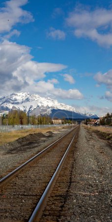 Téléchargez les photos : Une verticale de voies ferrées menant aux Rocheuses canadiennes Three Sisters Canmore - en image libre de droit
