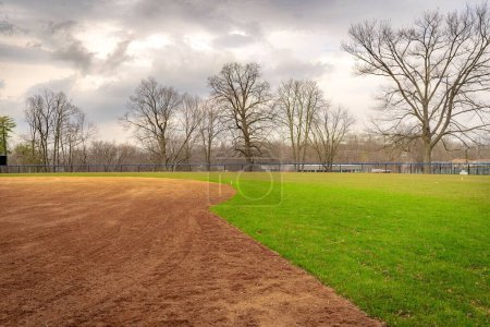 Foto de Vista del típico campo de softbol de secundaria con campo de arcilla desde la primera base del campo mirando hacia la segunda base. No hay gente visible. - Imagen libre de derechos