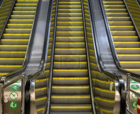 Foto de Un ángulo bajo de una vista de escalera mecánica con escaleras amarillas y tres líneas - Imagen libre de derechos