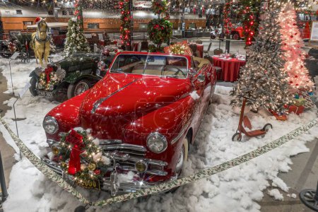 Téléchargez les photos : Une voiture rouge classique avec de la fausse neige et des décorations de Noël dans un musée - en image libre de droit