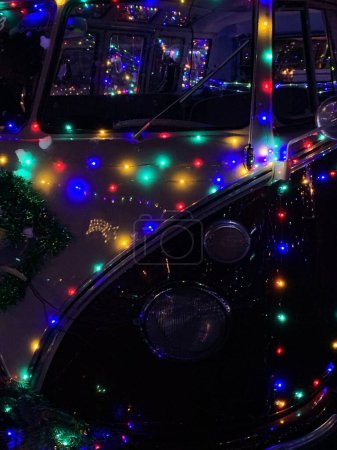 Téléchargez les photos : Un plan vertical de fourgonnettes couvertes de guirlandes légères lors du défilé de Noël à Oberhausen-Rheinhausen, Allemagne - en image libre de droit