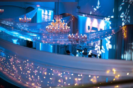 Téléchargez les photos : Un plan grand angle d'un lieu de mariage décoré avec des lumières et des lustres - en image libre de droit